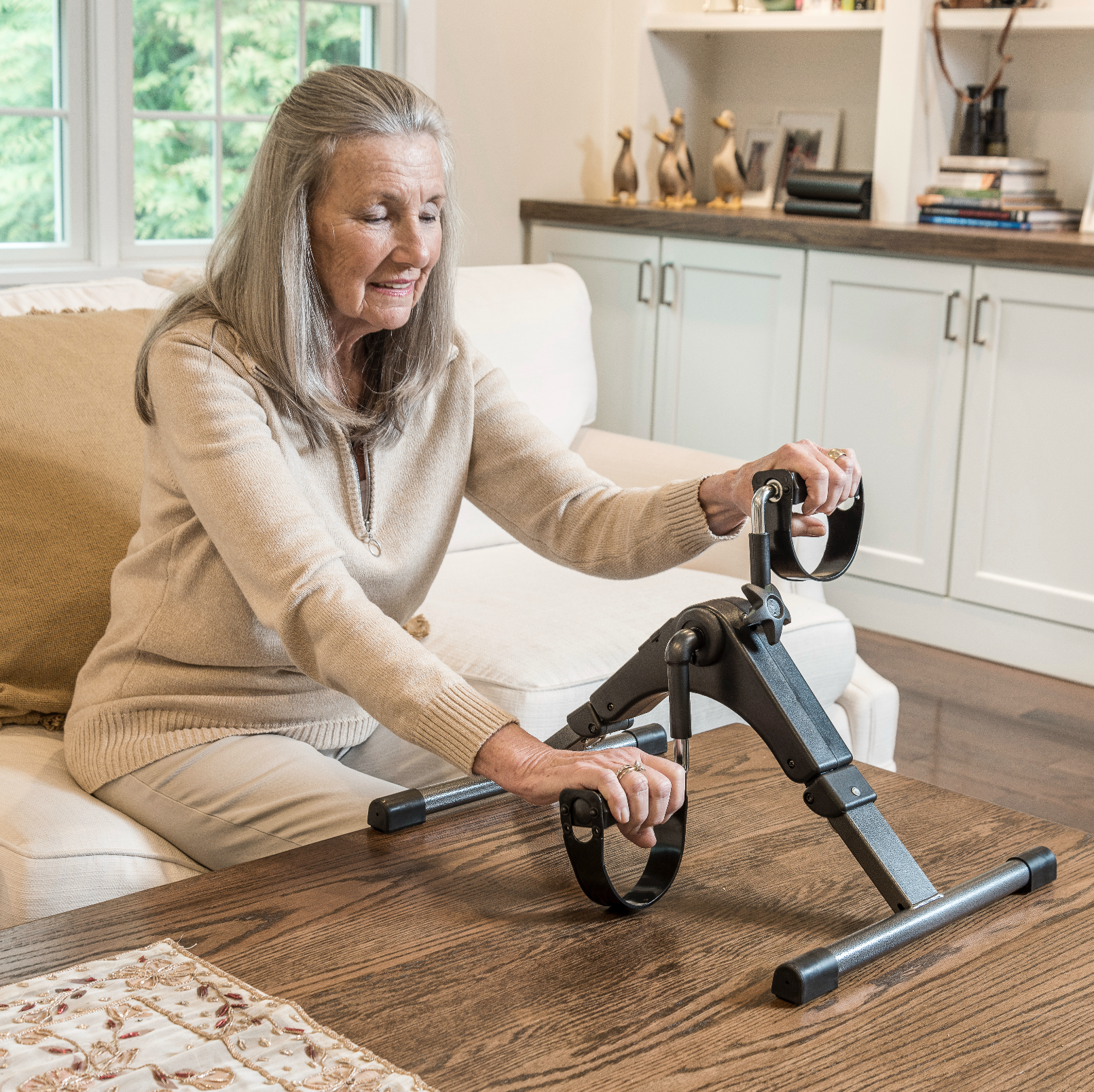 Woman using a home exercise device in a living room.