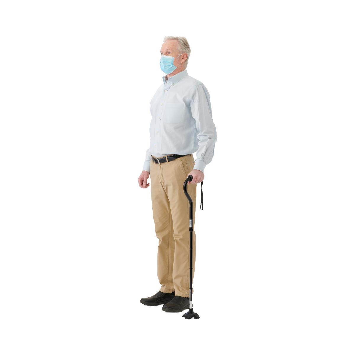 Man wearing a face mask and holding a walking cane on a white background