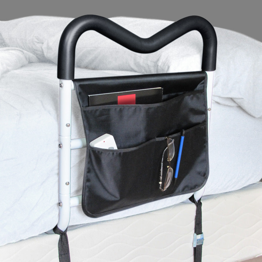 Black tray attached to a bed with various items in pockets