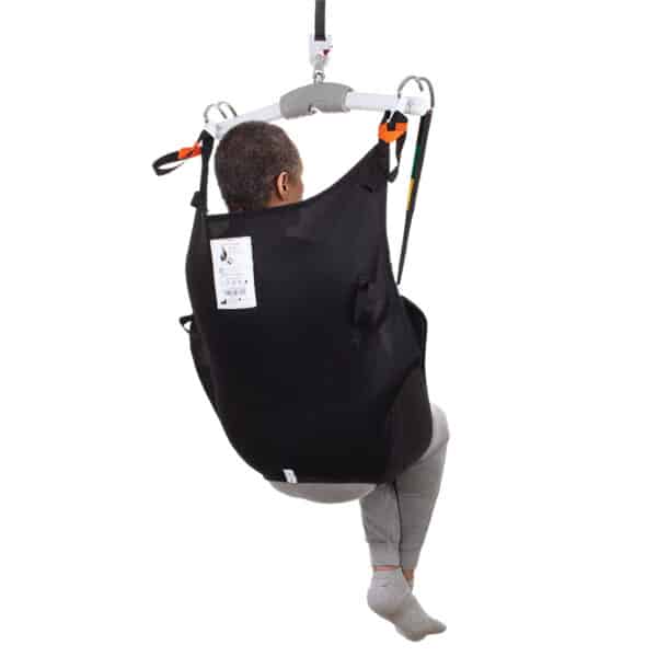 Person using a black medical sling with straps on a white background