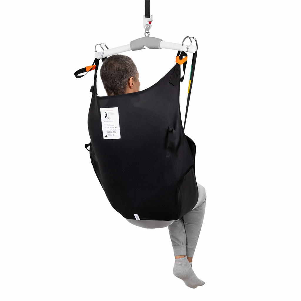 Person using a black medical sling for support on a white background