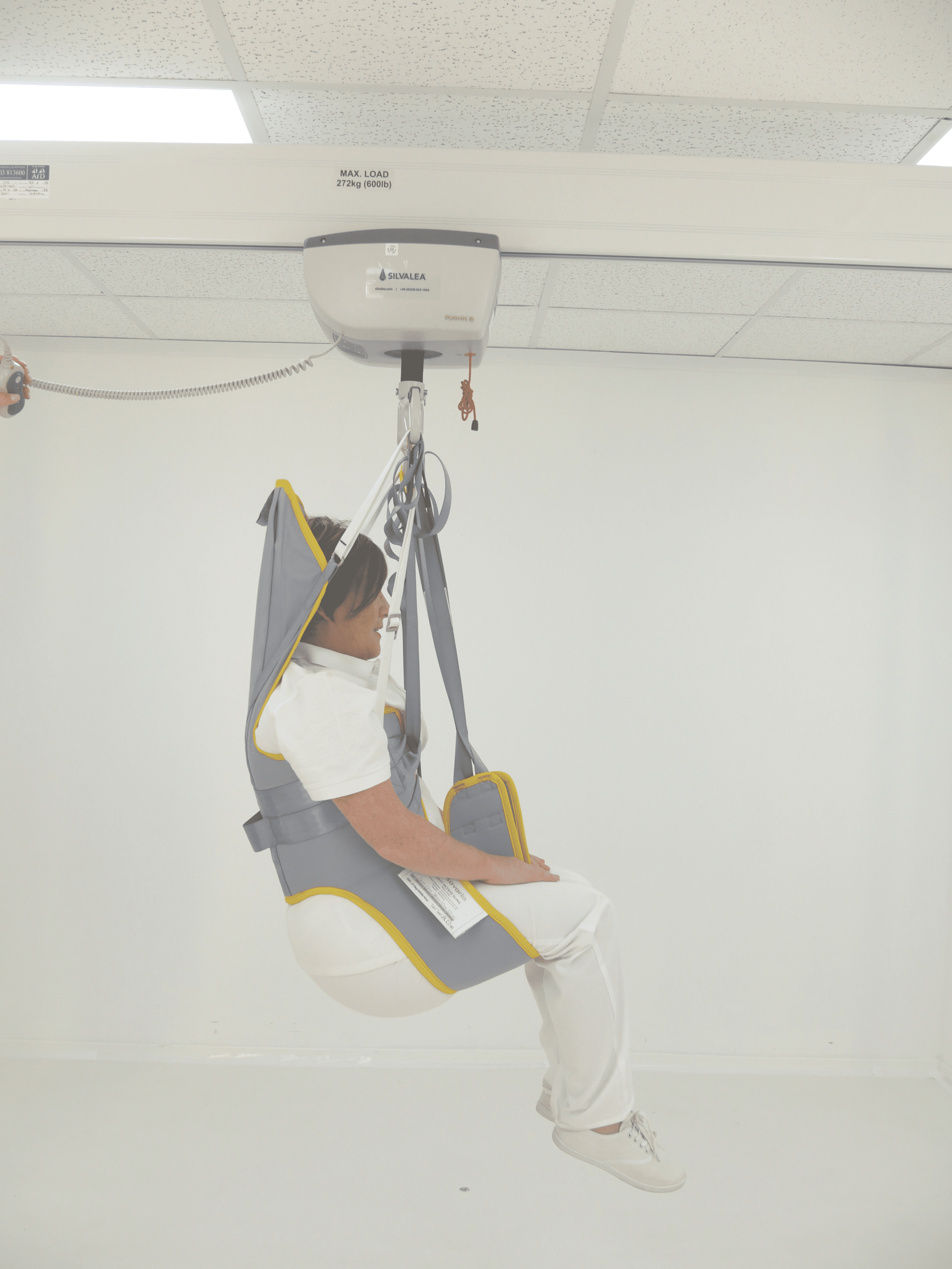 Person being hoisted using a medical lift in a clinical setting