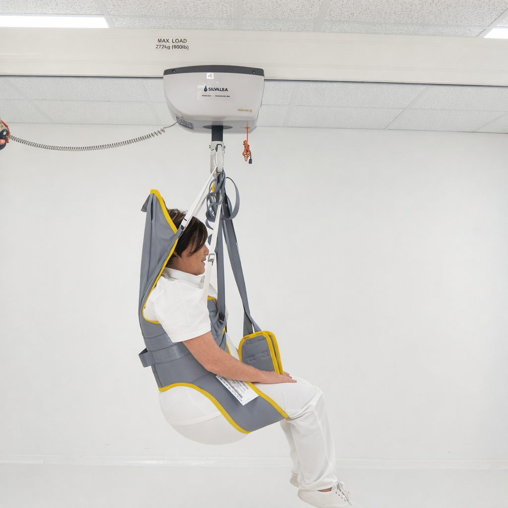 Person using a ceiling lift hoist in an indoor setting
