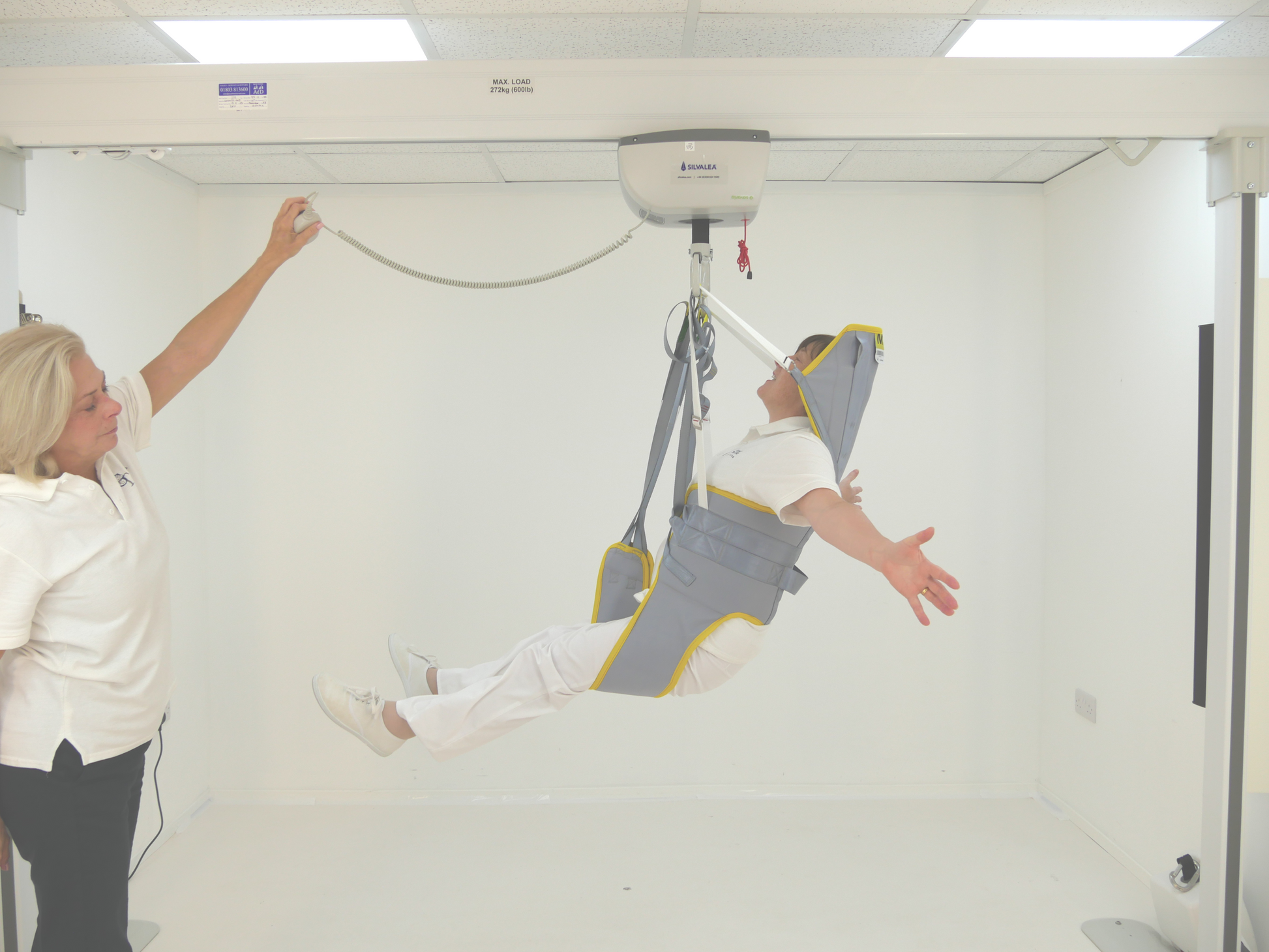 Person being hoisted by a medical lift in a clinical setting